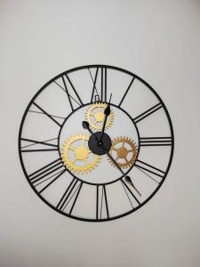 une horloge à deux faces sur un mur blanc dans l'établissement T2 la Voute Gontardaise, à Les Granges-Gontardes