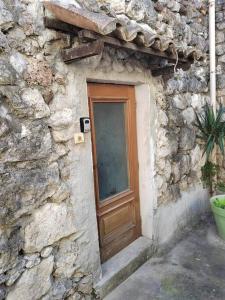 - un bâtiment en pierre avec une porte en bois et une fenêtre dans l'établissement T2 la Voute Gontardaise, à Les Granges-Gontardes