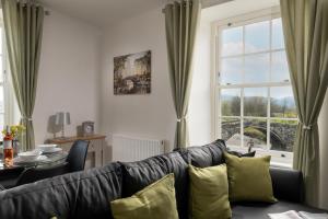 a living room with a couch and a window at Glan Conwy House One and Two Bedroom Apartments in Llanrwst