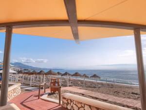 een uitzicht op een strand met parasols en de oceaan bij Bonito apartamento 2 minutos de la playa in Fuengirola