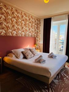 a bedroom with a large bed with a wall at Hôtel De Londres in Menton