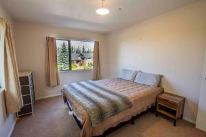 Schlafzimmer mit einem Bett und einem Fenster in der Unterkunft Two-Storey Apartment Main Street in Methven