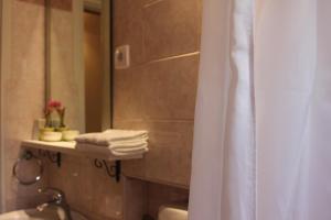 y baño con cortina de ducha y lavamanos. en Rooms Ena Rovinj, en Rovinj