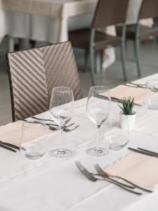マリーナ・ディ・ピエトラサンタにあるHotel Miltonのワイングラスとナプキンを盛り付けたテーブル