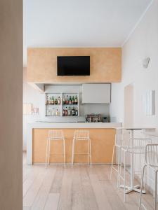 a kitchen with a bar with stools and a tv at Hotel Milton in Marina di Pietrasanta