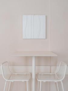 a white table with two chairs and a picture at Hotel Milton in Marina di Pietrasanta