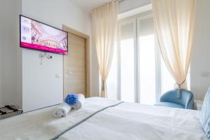 um quarto com uma cama e uma televisão na parede em B&B Home Flowers Milano em Milão
