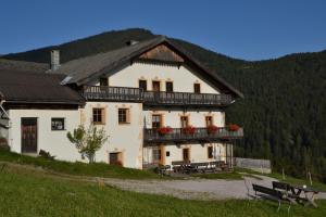 Cette grande maison blanche dispose d'un balcon. dans l'établissement Gostnerhof, à Dobbiaco