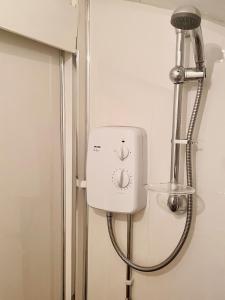 a shower head in a bathroom next to a door at Sheffield house on the hill in Manor