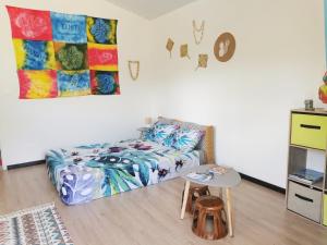 ein Schlafzimmer mit einem Bett und einem Tisch darin in der Unterkunft TAHITI - Orofero Lodge in Paea
