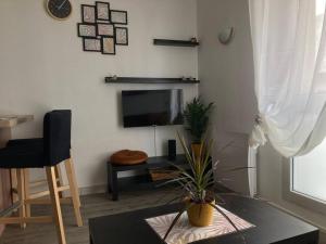 a living room with a tv and a glass table at Cozy'Nest in Brest