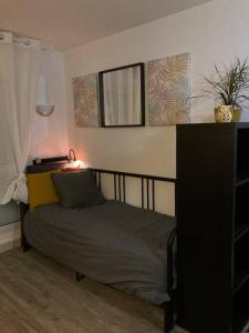 una camera da letto con un letto con una lampada e uno specchio di Cozy'Nest a Brest