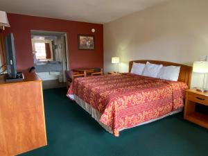 a hotel room with a bed and a flat screen tv at Travel Inn lackland Sea World in San Antonio +10 photos
