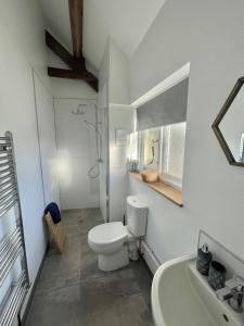 a white bathroom with a toilet and a sink at Furze in Watchet