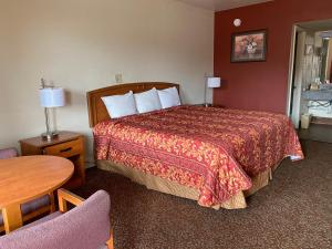 um quarto de hotel com uma cama e uma mesa em Travel Inn lackland Sea World em San Antonio