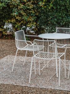two white chairs and a table and a table and chairs at Hotel Milton in Marina di Pietrasanta