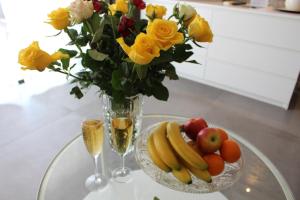 Residence Les Jardins De Lea في لا سين سور مير: طاولة زجاجية مع إناء من الزهور و صحن من الفواكه