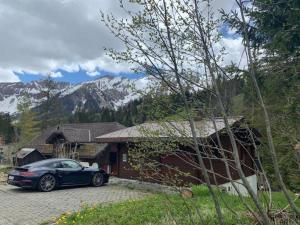 ein blaues Auto, das vor einem Haus parkt in der Unterkunft Chalet Bambi in Sörenberg