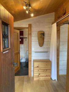 a bathroom with a toilet and a wooden wall at Chalet Bambi in Sörenberg