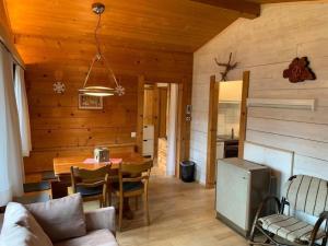 ein Wohnzimmer mit einem Tisch und einem Esszimmer in der Unterkunft Chalet Bambi in Sörenberg