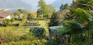 un giardino con vista sul lago e sulle montagne di Casa Dina a Lugano