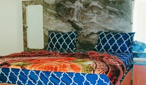 1 cama con edredón azul y 2 almohadas en Hotel Moon Light view, en Lahore
