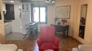 sala de estar con silla roja y cocina en Apartamento Bubal, en Panticosa