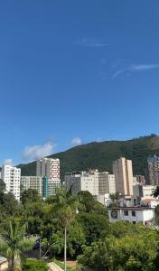 um horizonte da cidade com edifícios altos e árvores em Hotel Lux em Poços de Caldas