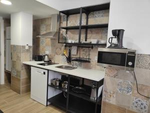 een keuken met een wastafel en een magnetron bij Apartamentos Pueblo Mar in Calpe