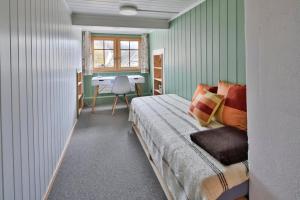 a bedroom with a bed and a desk in it at Haus zum Reh in Krummenau