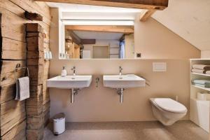 a bathroom with two sinks and a toilet at Haus zum Reh in Krummenau