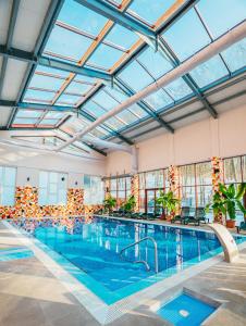 a large indoor swimming pool with a glass ceiling at Metropol in Baile Felix