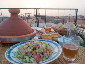 een tafel met een bord eten en een salade bij Terrace House 88 in Marrakesh
