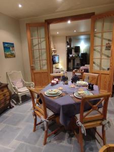 uma mesa de jantar com uma toalha de mesa azul em L 'Anima BB & table d'hôte em Helecine