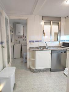 Apartamento Santa Pola في سانتا بولا: مطبخ أبيض مع حوض ومرحاض