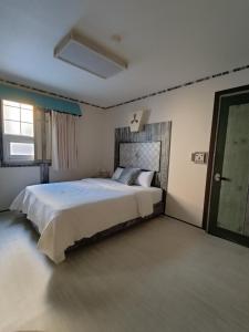 a bedroom with a large bed and a window at Athene Motel in Gwangju
