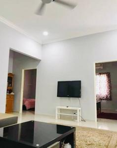 a living room with a flat screen tv on a white wall at Kundang Villa @ Tasik Biru - 3 Bedrooms Bungalow in Rawang