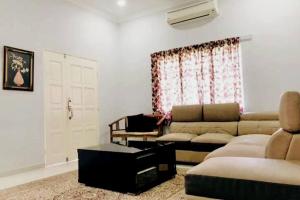 sala de estar con sofá y ventana en Kundang Villa @ Tasik Biru - 3 Bedrooms Bungalow, en Rawang