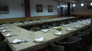 a row of tables in a room with chairs at Hotel Puente Romano in Alcántara