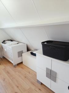 a attic room with white cabinets and a basket at Molière in Rekem