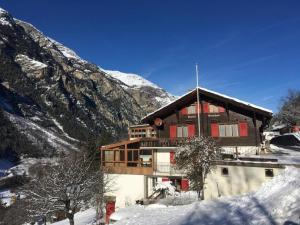 a building in the snow in front of a mountain at Wohnung Chalet Veilchen in Herbriggen