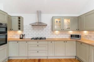 a kitchen with white cabinets and a stove top oven at Seahorses Crail in Crail