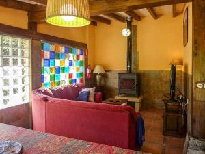sala de estar con sofá rojo y chimenea en Casa Rural Yolanda para 5 personas, en Arangas