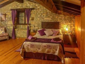 1 dormitorio con 1 cama en una pared de piedra en Casa Rural Yolanda para 5 personas, en Arangas
