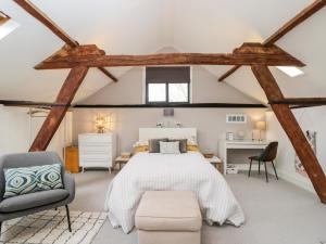 a bedroom with a large bed and a chair at The DunnitManor Farm in Salisbury