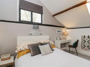 a bedroom with a large white bed and a desk at The DunnitManor Farm in Salisbury