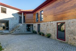 - un bâtiment en pierre avec un toit en bois et une terrasse dans l'établissement Carvalho Village, à Fafe