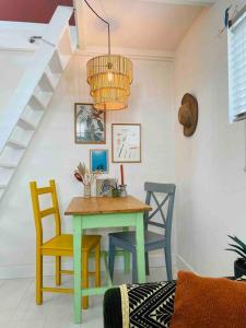 une table et des chaises dans une pièce avec un escalier dans l'établissement The Birdhouse, Tiny home close to the beach, à Noordwijk aan Zee
