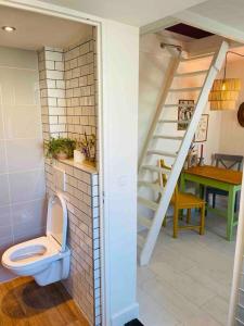 une salle de bains avec toilettes à côté d'un escalier. dans l'établissement The Birdhouse, Tiny home close to the beach, à Noordwijk aan Zee