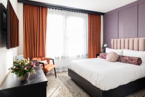 una camera d'albergo con letto, scrivania e finestra di Hotel Thaxter a Portsmouth